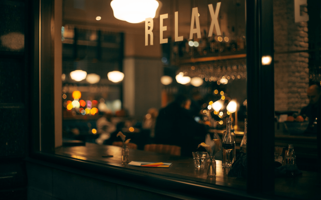 This is the glass screen door of a cafe that reads "Relax" signifying the tonal message of season 3 of "Insecure" which asks its black audience to give themselves grace for not being perfect or upholding Black excellence.