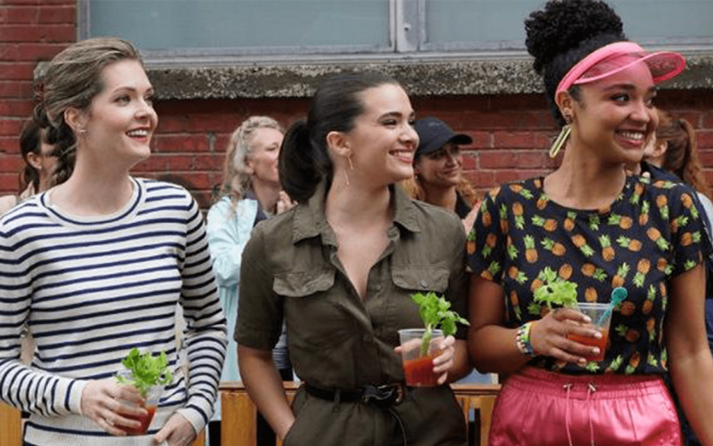 This is a picture of the three leads in "The Bold Type". The three women are looking towards the right of the frame, holding drinks.