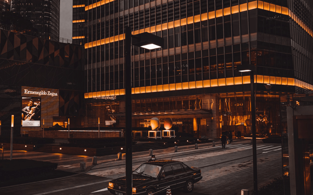 This is a cross walk with a black car in the road, an a building alight with orange lights. It features a sign that reads "Ermengildo Zegna". This represents the general sleek and business feel of succession, and the use of muted and yet appealing lighting represents the mystique of "Succession"