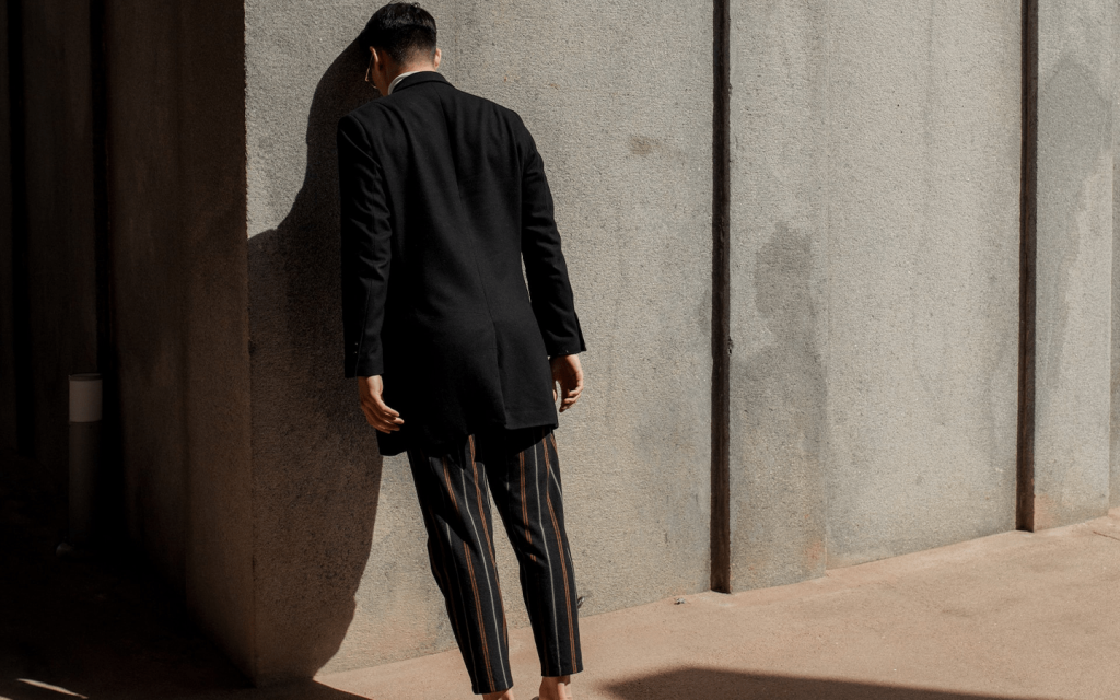 This is a man dress in business atire with his head leaning against the exterior wall of a brick building. This represents Lee Tae Oh in "The World of the Married".