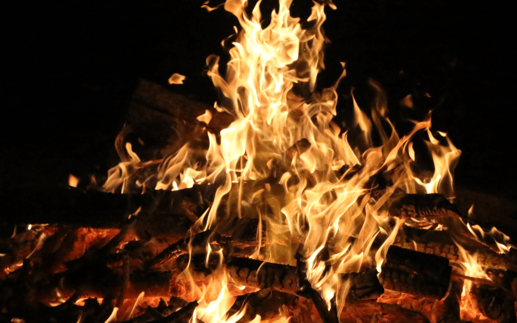 This is a camping wood pile with flames burning against a dark background used to represent the title of the movie "Burning".