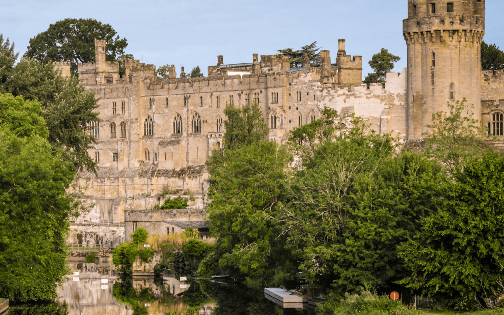 This is a castle by the lake and bushes which looks a lot like the castle in "Bridgerton".