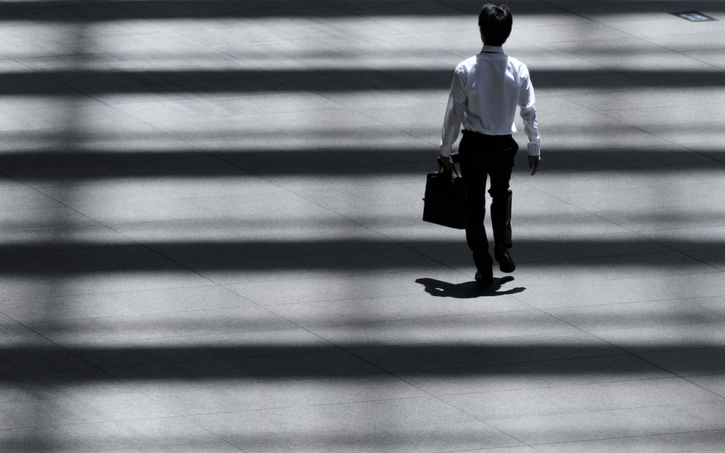 This is a man walking in a business district alone with a brief case representing the business people in the Waystar Royco team in Season 4 episode 1 of Succession